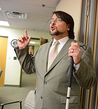 Joe Strechay in a suit speaking to a group of people