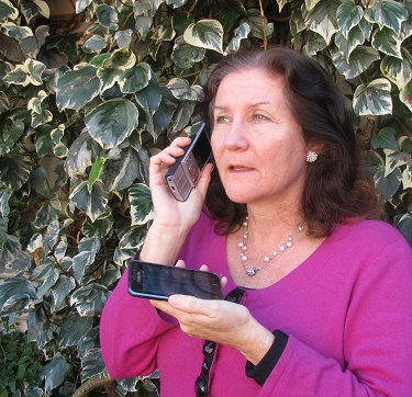 Maribel holding 'old faithful' to her ear and holding smartphone in her hand