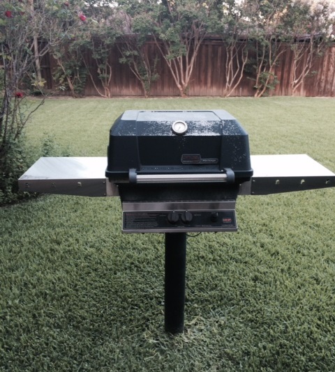 well used gas grill in yard