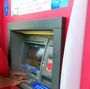 person who is blind with hands on ATM keyboard