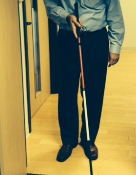 man holding mobility cane with several colors