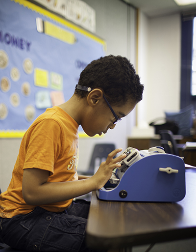 child at braillewriter