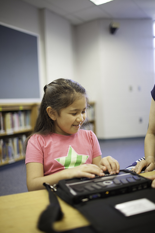 girl using braille notetaker