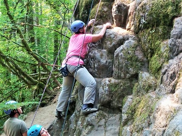 woman climbing cliff face