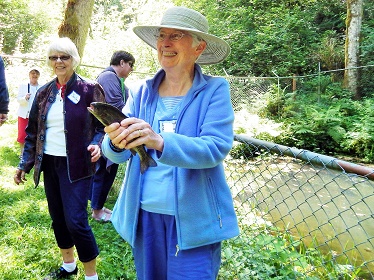 older woman holding fish and smiling