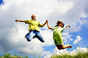 Jump of happiness people on blue sky and green grass background