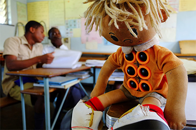 Image of a Braille Learning Doll with six buttons on the doll's stomach