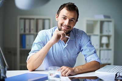 A man sitting at a desk looking at the camera