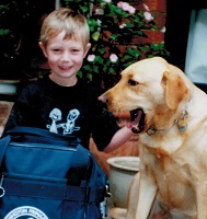 Little boy sitting with family guide dog