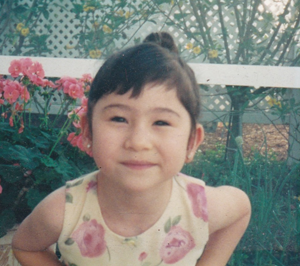 A young Michelle smiling directly at the camera