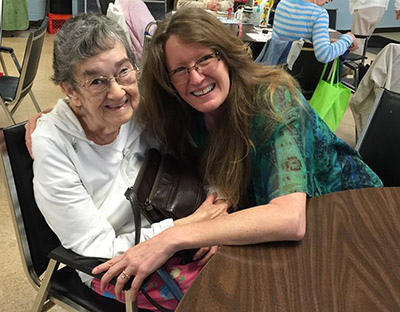 Melissa sitting with her mom at a senior center