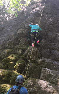Peer Advisor Audrey rock climbing on a mountainside