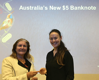 Maribel with a banknote representative holding the new currency