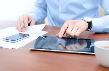 Man working on a smart phone and tablet