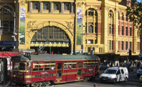 Flinders Street Station in Melbourne- Red double decker buses on the street
