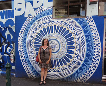 Maribel standing in front of colorful street art in Melbourne