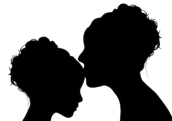 Silhouette of a mother kissing a daughter on the forehead