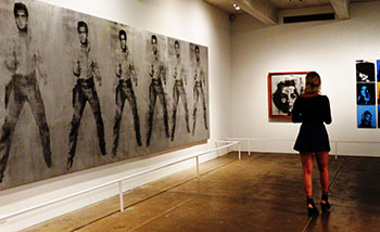 A woman in an art gallery with paintings hanging on the wall