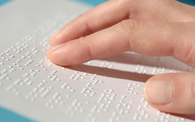 Hand moving over text in braille