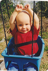 Jake at 18 months old sitting in a swing