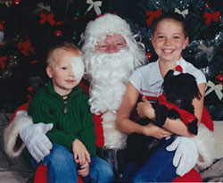 Jake with eye patch at toddler age with Santa