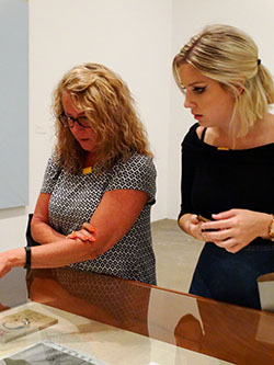 Two women looking at art in a glass display
