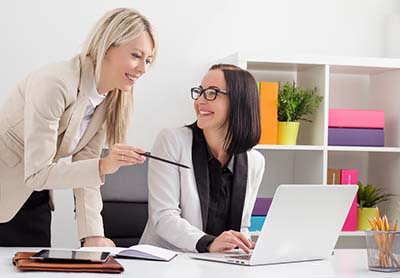 Two female colleagues working with a laptop computer