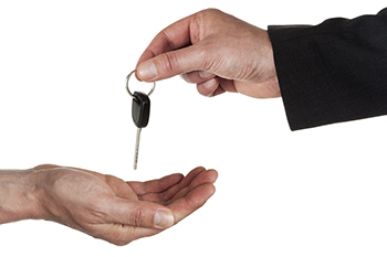 One hand holding a car key over another hand
