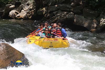 A group of campers and instructors white water rafting