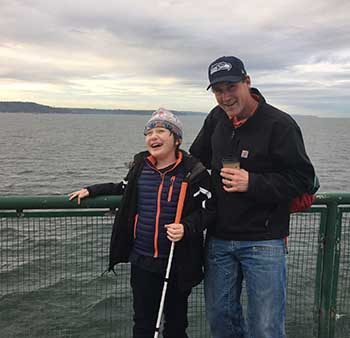 Eddie and his father standing in front of a fence on a ferry