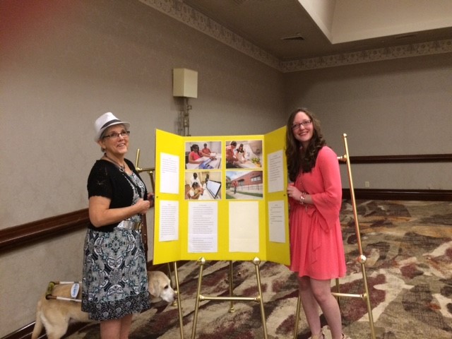 carol and grace standing by poster depicting Grace's story