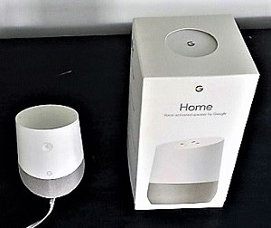 Google home device pictured next to packaging box for size perspective