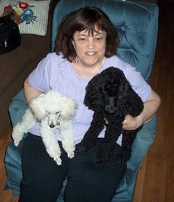 woman sitting in chair holding 2 dogs