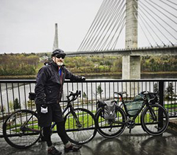 Mike Robertson from Shared Vision Quest standing outside with this bike in front of a bridge