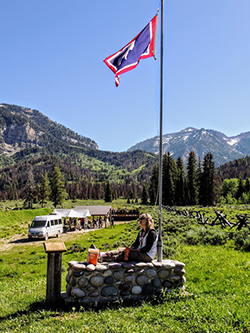 Emily Coleman sitting outside with her back against a flag pole in Jackson, Wyoming