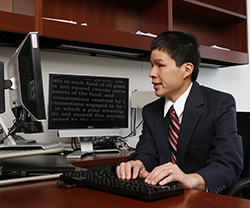 A man sitting at a desk working on a computer in his office