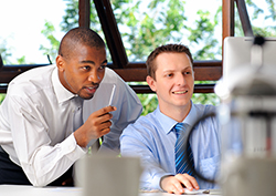 Two businessmen working together on the computer