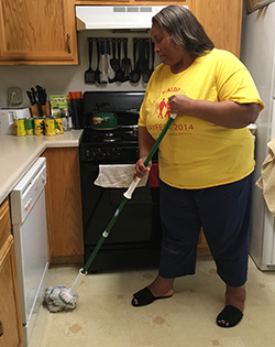 Empish mopping the floor in front of her dishwasher after it overflowed with bubbles