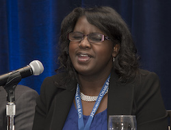 Denna Lambert speaking into the microphone during a panel at the 2017 American Foundation for the Blind Leadership Conference