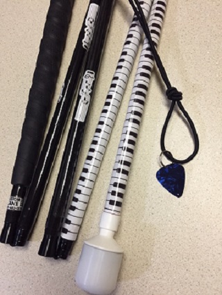 black and white mobility cane with musical keyboard motif