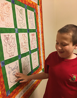 Eddie touching a picture quilt hanging on the wall 