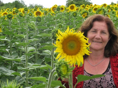 Maribel smiling and holding up sunflower 