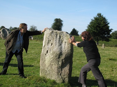 man and woman trying to move a very large rock