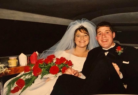 A young Emily Coleman in a wedding dress and her husband sitting in the back of a limo after their wedding