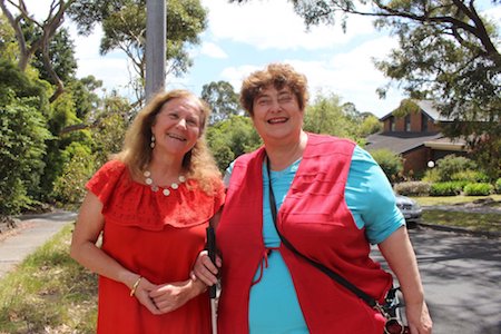 Maribel and Penny Melville-Brown standing together outside each wearing red clothing, image from Toby Melville