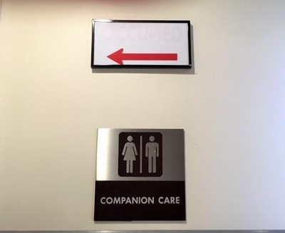 sign saying companion care and with symbols of woman and man and arrow pointing toward bath
