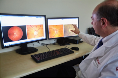 A doctor sitting at the reading center examining images of a patient's eye