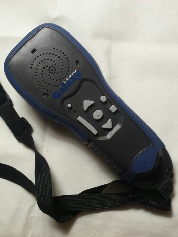 device resembling remote control for tv with shoulder carry showing array of tactile well-spaced buttons on the top of the hand-held remote