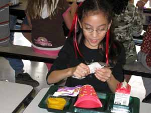 Elizabeth en el restaurante de la escuela que abre su vajilla de plata plástica