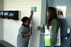 Child holding cane and reading sign in braille